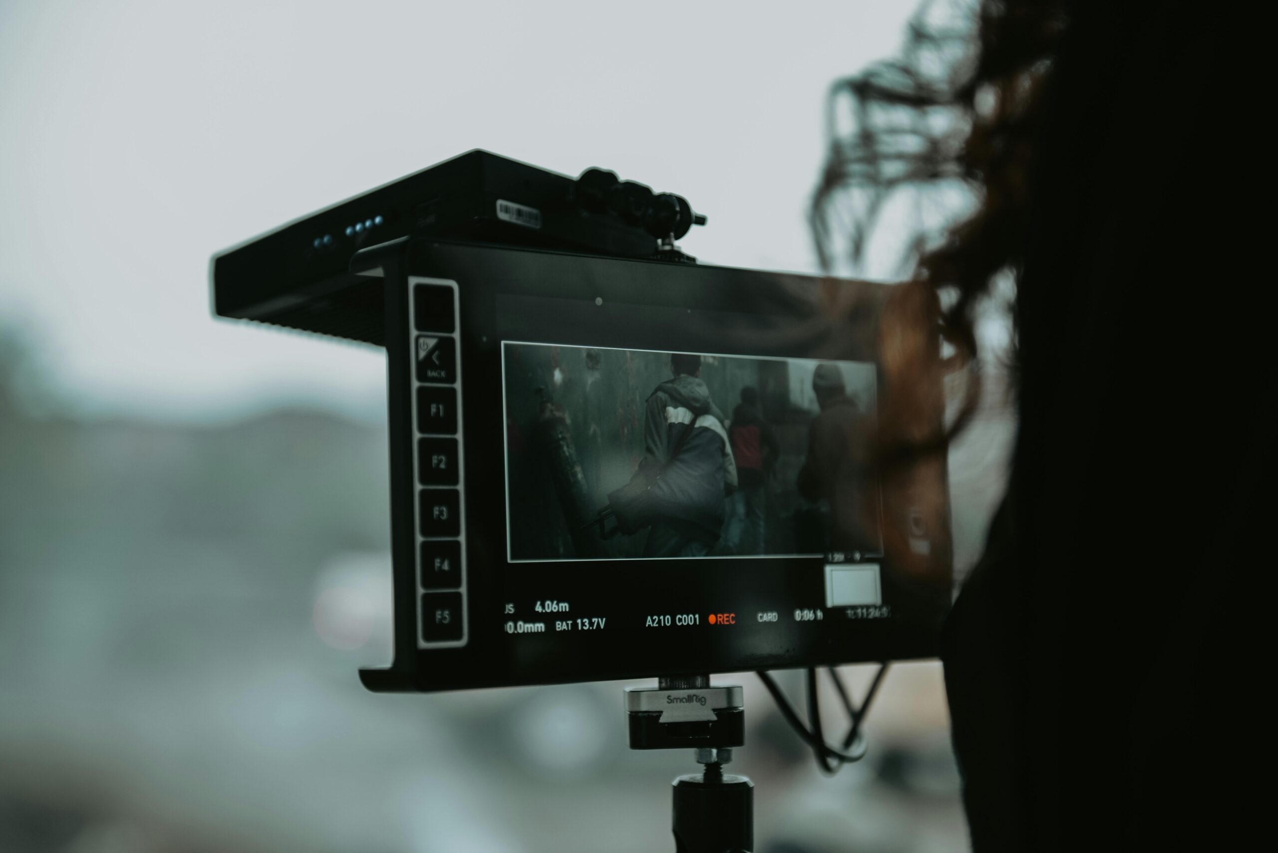 A close-up of professional filming equipment capturing a scene outdoors.